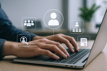 Person Using Laptop Keyboard with Digital Interface Icons in a Modern Office Setting.