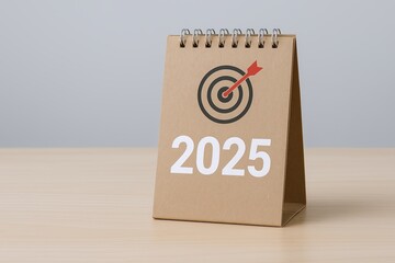Minimalist 2025 tabletop planner with target and arrow symbol on kraft paper cover.