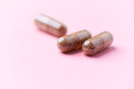 Siberian ginseng (Eleutherococcus senticosus) capsules on bright background. Soft focus. Close up. Copy space	