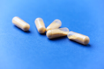 Coenzyme Q10 capsules. Antioxidants. Concept for a healthy dietary supplementation. Bright paper background. Soft focus. Close up. Copy space.	