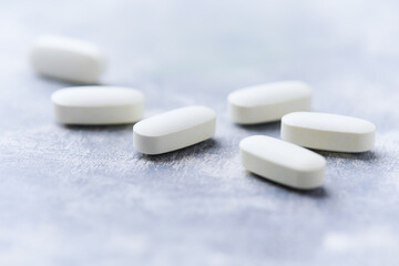 Amino acids tablets on wooden background. Soft focus. Close up	