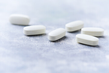 Amino acids tablets on wooden background. Soft focus. Close up	