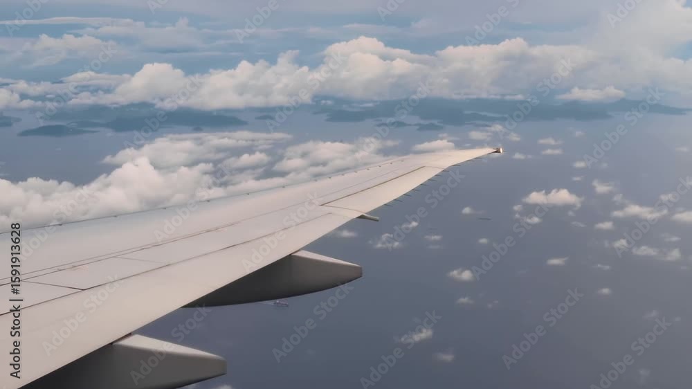 Poster aerial view of hazy islands from plane window during descent with clouds