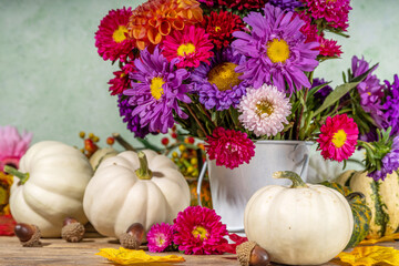 Flowers and pumpkins on table