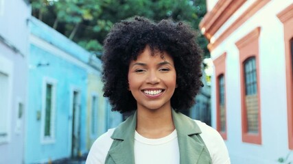 Beautiful young Black woman smiling confidently at the camera in a colorful street. Warm, joyful moment of connection, pride and authenticity. - Powered by Adobe