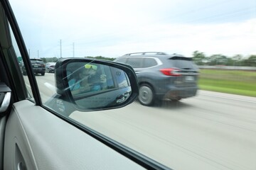 photographer reflect in rear mirror when car driving on a road