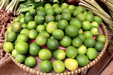 A close-up photo of a bunch of fresh green limes. These citrus fruits have a sour and refreshing...