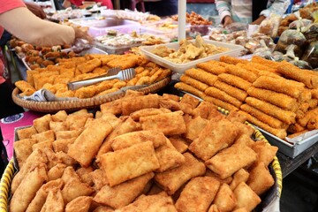 Delicious and warm stuffed risoles are being sold at a traditional snack stall. Risoles is a traditional Indonesian food that can be filled with chicken, vegetables, meat, corn, and mayonnaise.