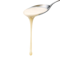 A close up of a spoon holding and dripping a creamy white liquid substance down on transparent background