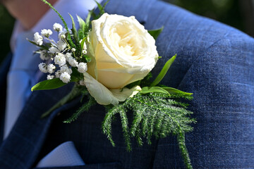White rose buttonhole on suit. 