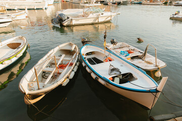 Small fishing boats floating peacefully in calm harbor waters at golden hour