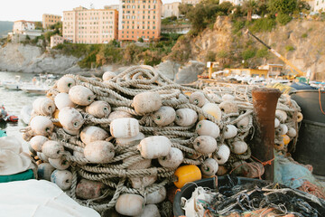 Fishing nets and floats piled up on a dock in camogli, italy