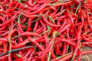 Curly red chilies at a traditional market. A background of spicy and fresh red chilies. A common ingredient in Asian cuisine.