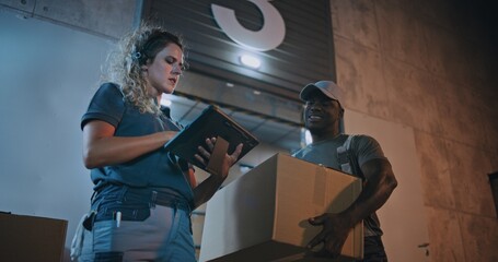 Diverse Employees Carrying Cardboard Boxes from Logistics Warehouse, Working at Night. Female...