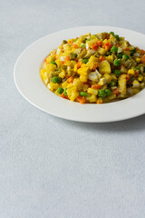 This dish features a vibrant salad composed of boiled eggs, tender chicken breast, diced potatoes, sweet carrots, and fresh green peas, all topped with a drizzle of olive oil for flavor