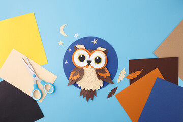 Colorful handmade paper owl on starry blue background for children products, toy brands, classroom...