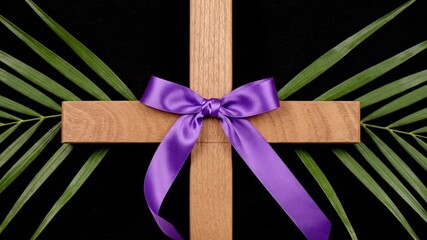 Wooden cross with purple ribbon set against dark background with palm leaves