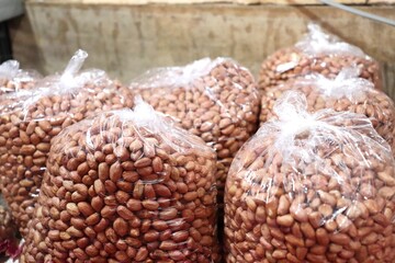 Shelled peanuts packed in clear plastic bags for sale. The peanuts are ready to use for cooking,...