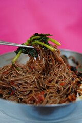 Close-Up of Korean Buckwheat Noodles with Spicy Sauce and Vegetables in Metal Bowl