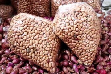 Shelled peanuts packed in clear plastic bags for sale. The peanuts are ready to use for cooking,...