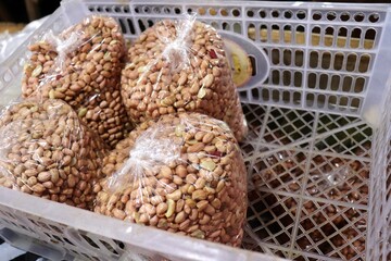 Shelled peanuts packed in clear plastic bags for sale. The peanuts are ready to use for cooking,...