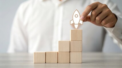 Figure placing rocket icon on top of blocks — building toward a launch-ready business