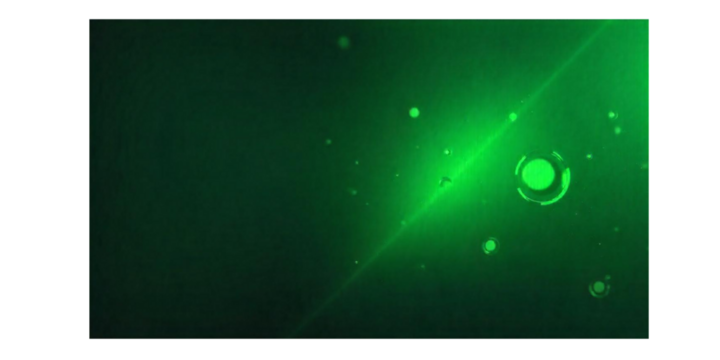 an abstract depiction of green light and circular shapes against a dark background.