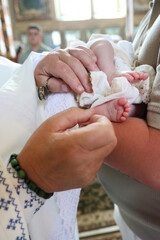 Baptism ceremony. Priest performs chrismation of newborn