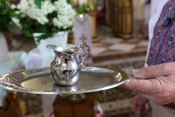 A bowl of holy water on a tray. Holy water is a symbol of a church rite.