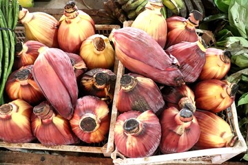 Fresh banana blossoms neatly displayed for sale at a traditional market stall.