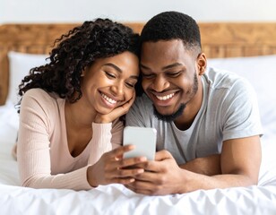 Happy couple looking at phone in bed