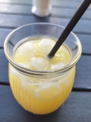 Refreshing citrus drink filled with ice on a sunny outdoor table