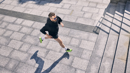 Man jogs on a sunny day embodying commitment to midlife fitness and healthy lifestyle. Concept of...