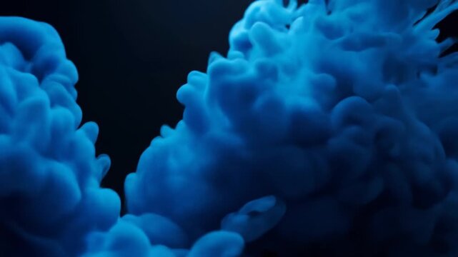 Blue ink dissolving in dark background