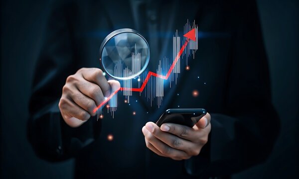 Businessman analyzing financial data with magnifying glass and smartphone, highlighting market trends and economic downturn concept. Market trends.