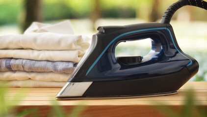 Eco-friendly ironing concept with iron on wooden in nature