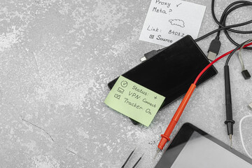Modern OSINT setup with smartphone, tablet, probes, cables, sticky notes with investigative hints