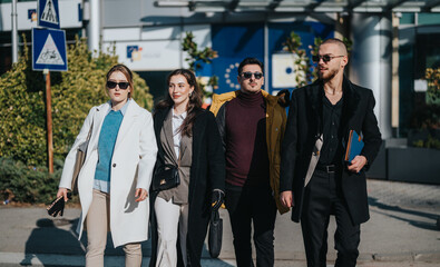A group of young professionals strolls in sync on a sunny day, exuding confidence and modern...