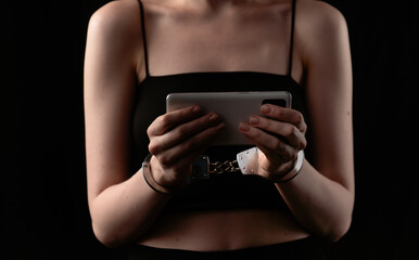 Woman with Handcuffs Holding a Smartphone in Low Light