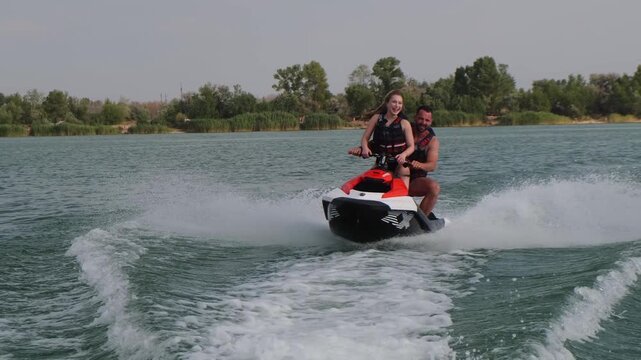 Happy couple riding a jet ski on a lake. Concept joy, togetherness, and summer adventure.