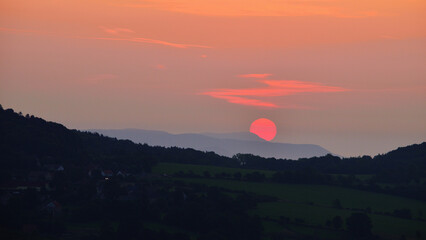 Red Sunrise with Sun Disk Rising Above Hilly Horizon in Czech Landscape