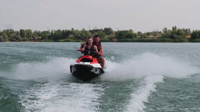 Happy couple riding a jet ski. Concept joy, freedom, and shared adventure.