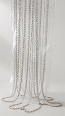 Elegant display of silver chains against white background for jewelry and fashion concepts