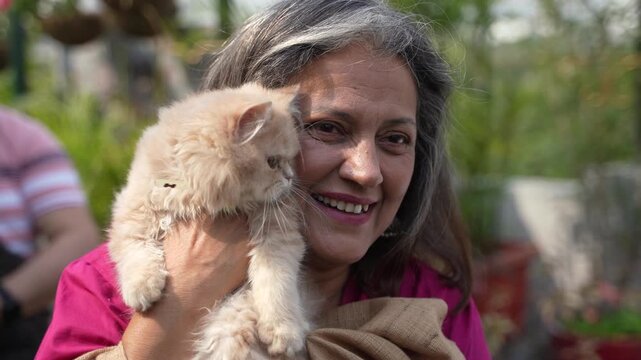 Indian senior woman with cat at home