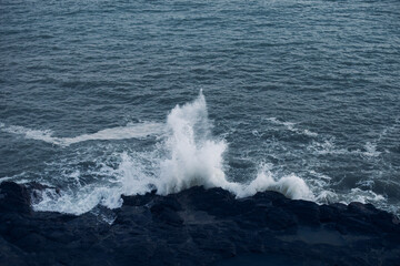 Moody Blue Coastal Waves Crashing Over Submerged Rocky Shoreline
