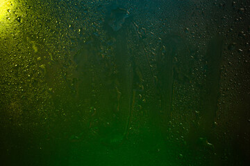 Wet glass. Water drops on dark glass. Abstract texture. Multicolored spots