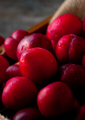 Delicious and Juicy Red Plums.

Vibrant red plums, ripe and ready to eat, arranged in a wooden crate. Ideal for food bloggers and culinary publications.