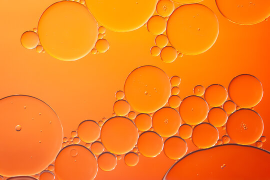 Oil bubbles. Oil bubbles on water in orange tones close-up. Abstract texture