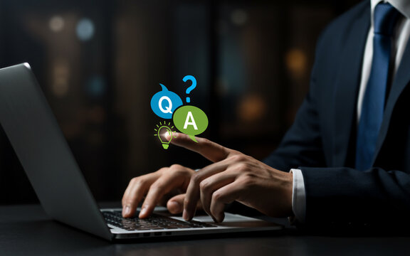 Online Support Q&A,
Businessman pressing question and answer icons on laptop — customer service, technical support, and helpdesk access