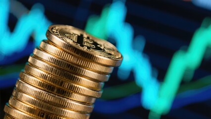 Stack of golden bitcoin coins with financial chart in the background, cryptocurrency.